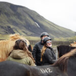 A female traveller riding horses in Iceland